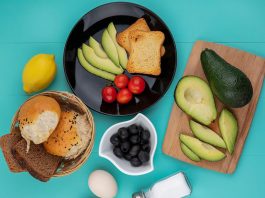 Top View Fresh Avocados Wood Kitchen Board With Avocado Slices Tomatoes Black Plate With Bucket Breads Blue