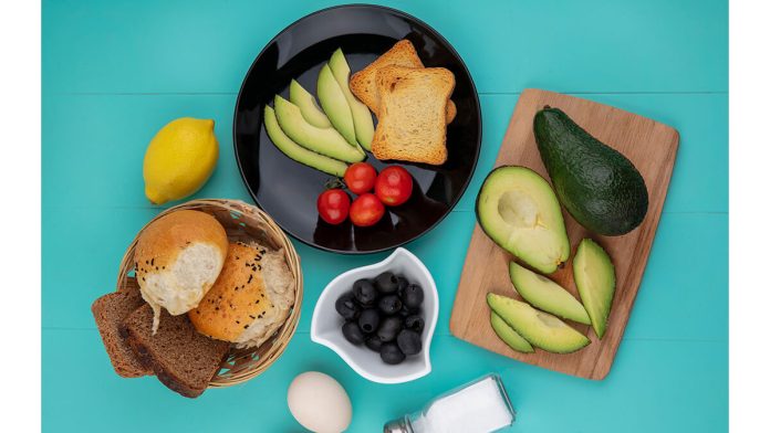 Top View Fresh Avocados Wood Kitchen Board With Avocado Slices Tomatoes Black Plate With Bucket Breads Blue
